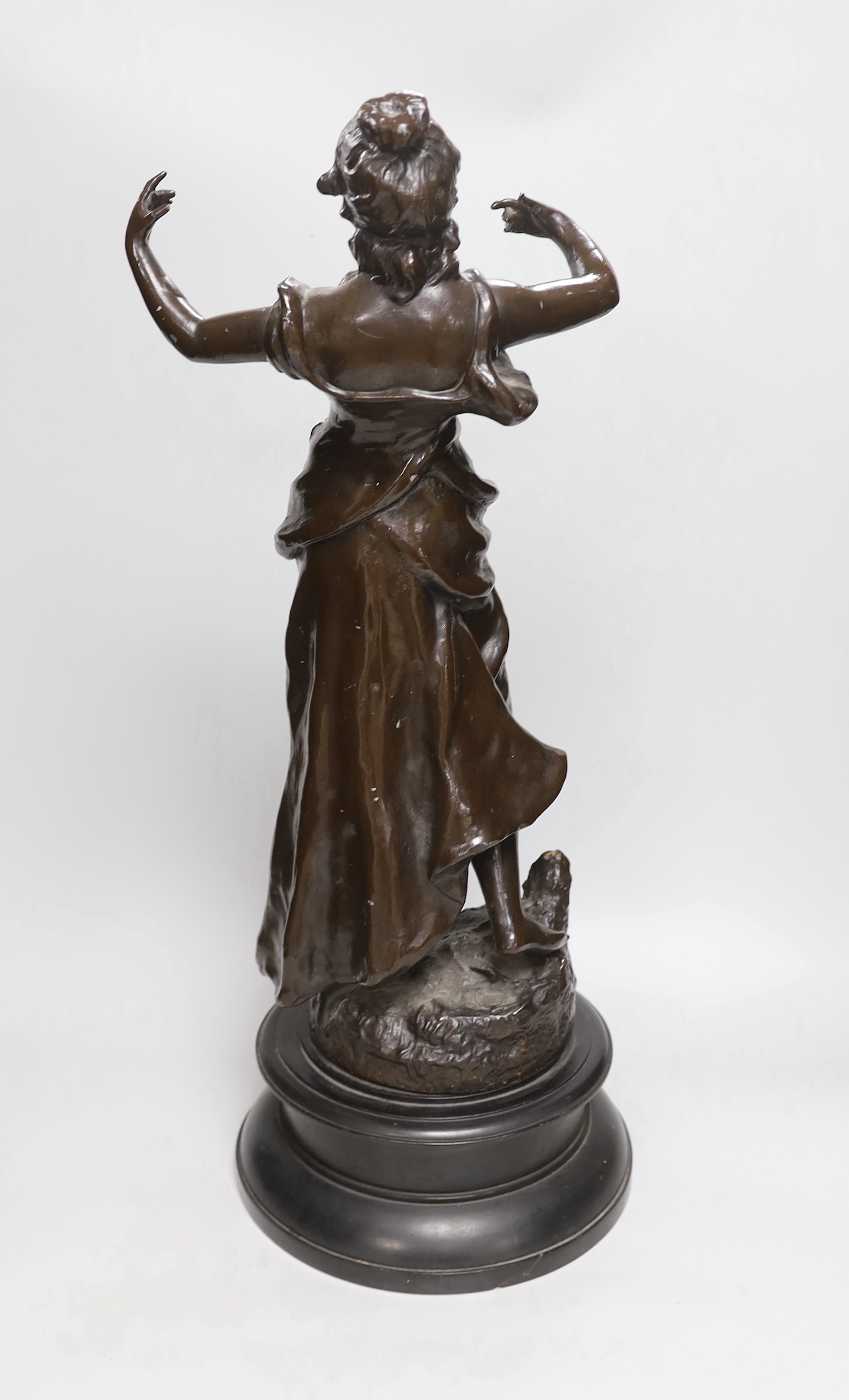 A large bronzed spelter figure of a female on an ebonised wooden base, height 55cm